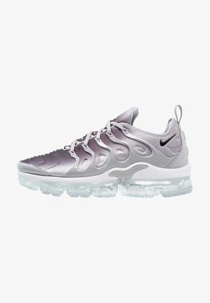 Grijs-witte Nike hardloopschoen met een verloopkleur bovenwerk, gevormde kooi-overlays, zwarte swoosh, trekkoord en transparante luchtgeveerde zool.