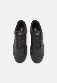 Schwarze Sneaker mit einer glatten Lederobermaterial, runder Zehenpartie, perforierten Akzenten, flachen Schnürsenkeln und gepolstertem Innenraum, mit einem Logo auf der Zunge.