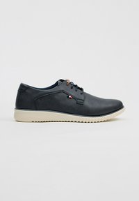 Zapatos de cordones en cuero azul oscuro con una textura suave, suela de goma beige y un pequeño detalle de logo en el costado.