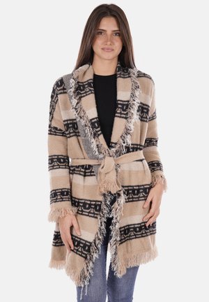 Cardigan a scialle beige e nero con motivo e bordi frangiati, apertura frontale e cintura annodata. Texture morbida e design casual, adatto per essere indossato a strati.