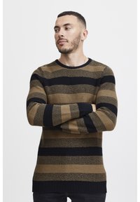 Il maglione a righe presenta strisce orizzontali marroni e nere, un tessuto a maglia testurizzato, collo rotondo e polsini e orlo a costine.
