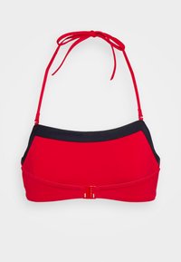 Top de biquíni vermelho com detalhes em preto, alças ajustáveis e fecho central. Textura suave com uma forma estruturada.