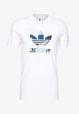 T-shirt Adidas blanc à manches courtes avec logo trèfle camouflage bleu et texte Adidas centrés sur le devant.