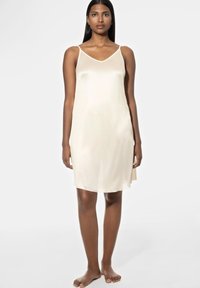 Slipdress van lichtbeige satijnstof, met dunne bandjes, een V-hals en een losse pasvorm, die net boven de knieën valt.