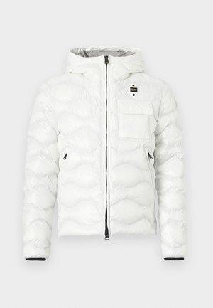 Bela prešita puhovka z kapuco, črnim zadrgo, žepom z zaponko na prsih, dvema stranskima žepoma z zadrgo in črnim okrasom na zapestjih.