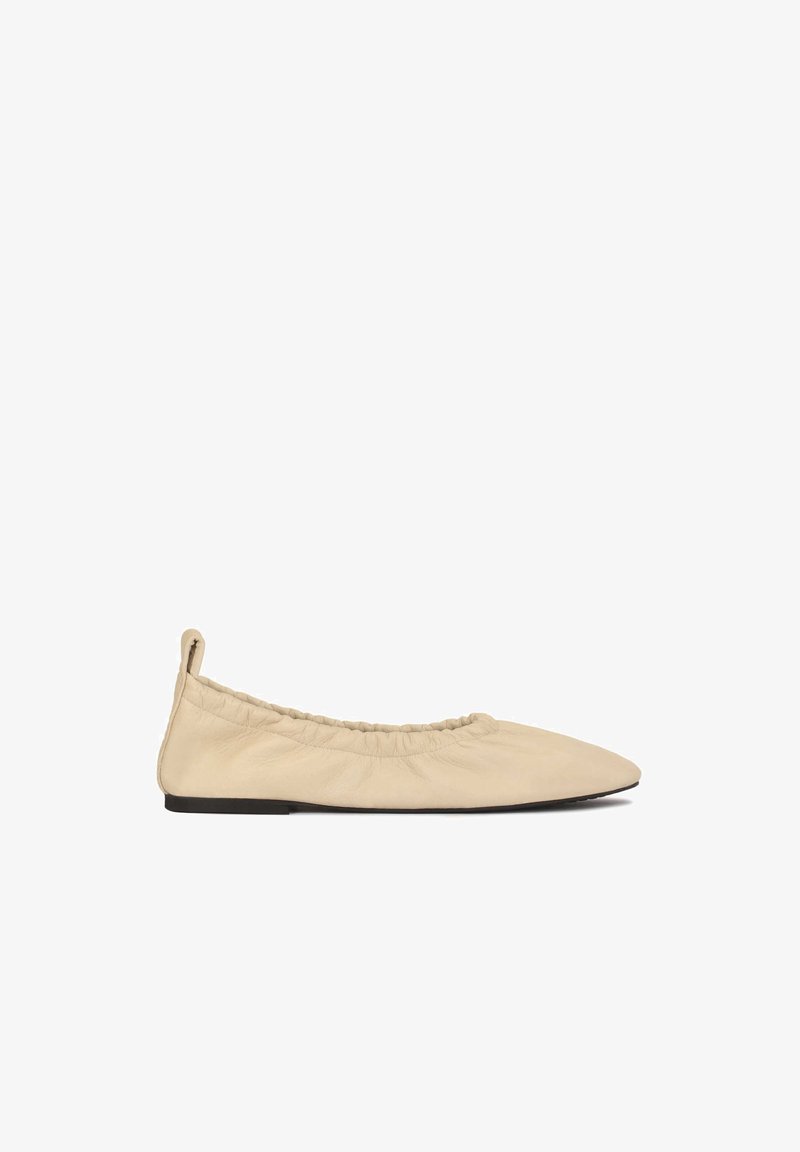 Bailarinas de cuero beige con una abertura elástica arrugada, punta afilada y suela plana. Textura suave con un diseño minimalista.