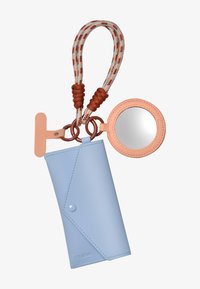 Custodia in pelle azzurro chiaro con chiusura a scatto, attaccata a una tracolla intrecciata marrone e crema con texture, caratterizzata da uno specchio rotondo rosa.