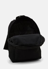 Sac à dos noir avec une forme arrondie, doté d'un grand compartiment principal et d'une petite poche avant. Fabriqué en tissu durable avec des fermetures éclair.
