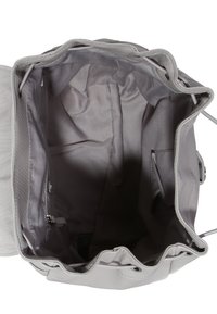 Grå tygväska med en mjuk, slät textur. Har en öppen topp, inre fickor och en dragsko för att säkra innehållet.