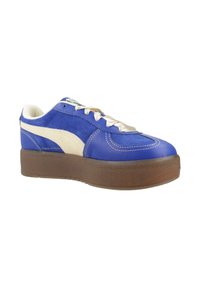 Baskets basses bleu et blanc avec une semelle épaisse marron, des lacets blancs et une bande blanche sur le côté.