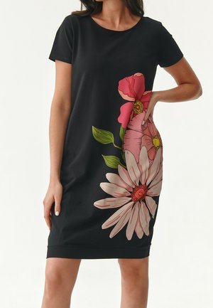 Robe courte noire à manches courtes avec de grandes impressions florales roses et blanches d'un côté. Confectionnée dans un tissu lisse avec une silhouette cintrée.