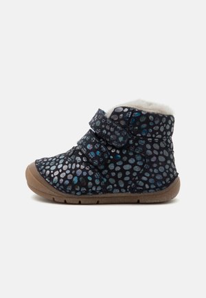 Enkellaarsje voor kinderen met zwart-blauw gestippeld patroon, twee klittenbandsluitingen, een zachte witte voering en een bruine rubberen zool.