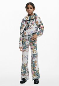 Pullover und Hose aus weichem Stoff, mit einem mehrfarbigen Blumen- und Cartoon-Muster. Die weit geschnittenen Hosen unterstreichen die lockere Passform.