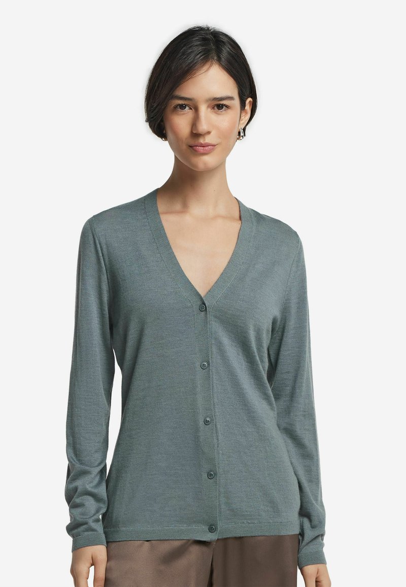 Grön v-ringad cardigan i mjukt stickat tyg, med sex framknappar, långa ärmar och en avslappnad passform. Enkelt och mångsidigt design.