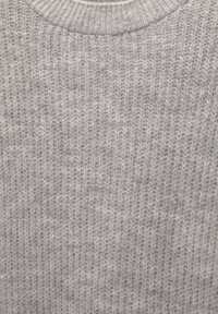 Pull tricoté gris clair avec une texture côtelée et un col rond. Le tissu semble doux avec un motif régulier et uniforme sur toute la surface.