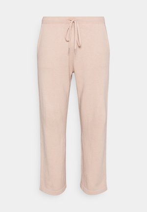 Calças de moletão rosa claro feitas de um tecido suave, com uma cintura ajustável por cordão e pernas retas curtas com um acabamento ligeiramente texturizado.