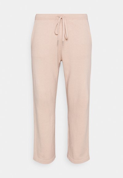 Calças de moletão rosa claro feitas de um tecido suave, com uma cintura ajustável por cordão e pernas retas curtas com um acabamento ligeiramente texturizado.