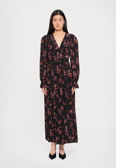 Vestido maxi negro con flores, de mangas largas, escote en V y cintura atada. Presenta patrones florales en púrpura y naranja sobre una tela texturizada.