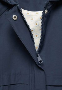 Granatowa kurtka z zamkiem błyskawicznym z przodu i wewnętrzną podszewką w kwiatowy wzór. Posiada zapięcie na napy oraz gładką teksturę materiału.