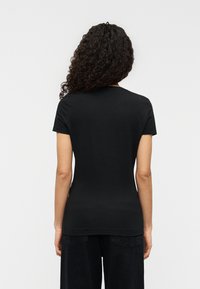 Μαύρο κοντομάνικο μπλουζάκι από απαλό βαμβάκι, με κλασικό στρογγυλό λαιμό και καλοραμμένη εφαρμογή, εμφανιζόμενο από πίσω.