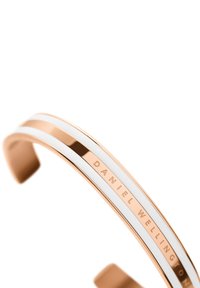 Rožinio aukso apyrankė su kompaktišku dizainu, puošta dviem baltomis juostelėmis. Išgraviruotas tekstas "DANIEL WELLINGTON" pabrėžia prekinį ženklą.