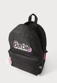 Črn nahrbtnik iz blaga z velikim rožnatim logotipom "Barbie", z ziperskim glavnimi predalom, sprednjim žepom in rožnato pom-pom ključavnico kot dodatek.