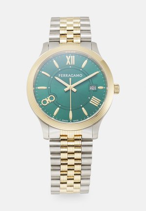 Goud- en zilverkleurig horloge met een groene wijzerplaat, voorzien van Romeinse cijfers, gouden wijzers, datumaanduiding en een bicolor roestvrijstalen armband.