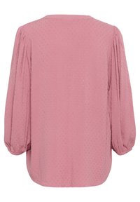 Blouse rose avec de longues manches bouffantes et un col rond. Tissu texturé présentant un motif à pois subtil sur l'ensemble.