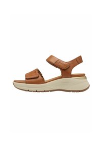 Braune Leder-Sandale mit verstellbaren Riemen, gepolstertem Fußbett und leichtem cremefarbenem Schuhboden mit Rillen für besseren Halt.