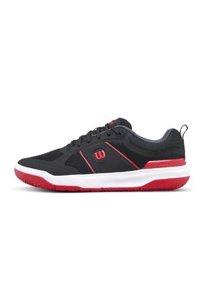 Chaussure de sport noire et rouge avec semelle blanche, dessus en mesh, fermeture à lacets et logo Wilson sur le côté et la languette du talon.