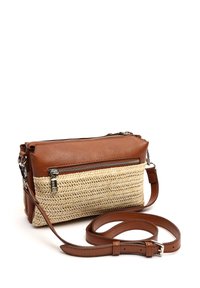 Pruunist nahast ja kootud õlgi risti kott, millel on kaks lukuga osa ja eemaldatav rihm. Omab keerukat kudumise mustrit.