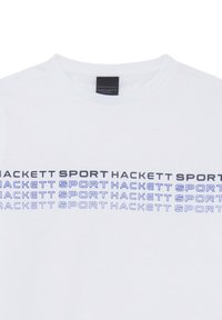 Biała koszulka z okrągłym dekoltem, z powtarzającym się napisem "HACKETT SPORT" w odważnych czarnych i niebieskich kolorach z przodu.