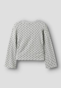 Graues Langarmshirt mit Rundhalsausschnitt, kurzem Schnitt und gleichmäßig verteilten schwarzen Punkten auf dem Stoff. Weiche Textur.