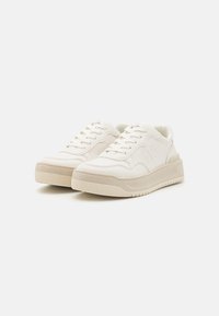 Sneaker bianche basse in pelle liscia con suola testurizzata, dotate di chiusura con lacci e un logo incavato discreto sul lato.