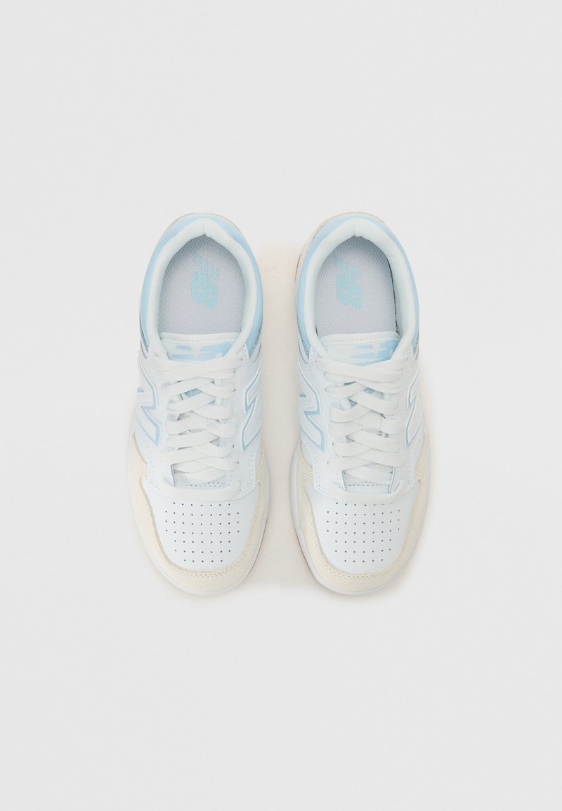Zapatillas blancas con acentos en azul claro. Fabricadas en cuero suave, con puntera perforada, cordones clásicos y suela de goma texturizada.