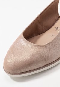 Beige platte schoen met een ronde neus, suede-achtige textuur, een lichte glans en een verzonken rand. Het interieur is soepel met een minimalistisch ontwerp.
