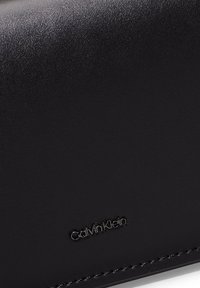 Calvin Klein GLOW CHAIN MINI BAG - Alkalmi kézitáska - black
