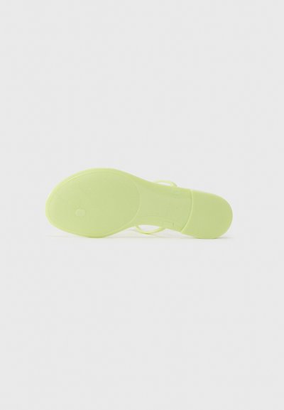 Sandală verde lime cu un toc mic și o talpă netedă, texturată. Are un design simplu, cu benzi minime. Suprafața este lucioasă și flexibilă.