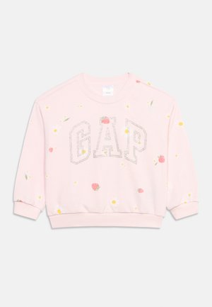 Svetlo roza pulover z napisom GAP, obrobljenim z majhnimi cvetovi, okrašen z raztresenimi jagodami ter rumenimi in belimi cvetličnimi vzorci.