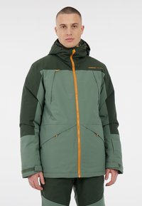 Grüne zweifarbige Winterjacke mit hohem Kragen, verstellbare Kapuze, orangefarbenem Reißverschluss und Reißverschlusstaschen. Glatte Textur, strapazierfähiges Material.