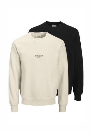 Two sweaters displayed: one cream-colored and one black. Both feature a crew neckline, long sleeves, and ribbed cuffs. "JJ Studios" logo on front.