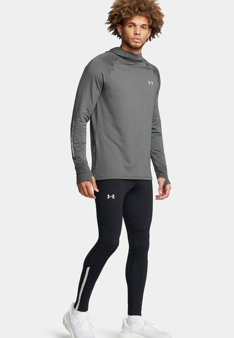 Sportliches Langarmhemd in Dunkelgrau mit steigendem Kragen und strukturiertem Muster, kombiniert mit schwarzen Leggings mit weißen Seitenstreifen.
