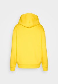 Geel hoodie met een relaxed fit, gemaakt van zacht materiaal. Beschikt over een grote capuchon en ribgebreide manchetten bij de mouwen en onderkant.