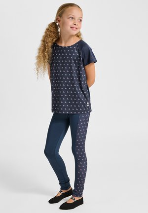 Marineblåt sportsoutfit med kortærmet top med lille pink mønster og matchende leggings med mønsterdetalje på siden. Sorte sko.