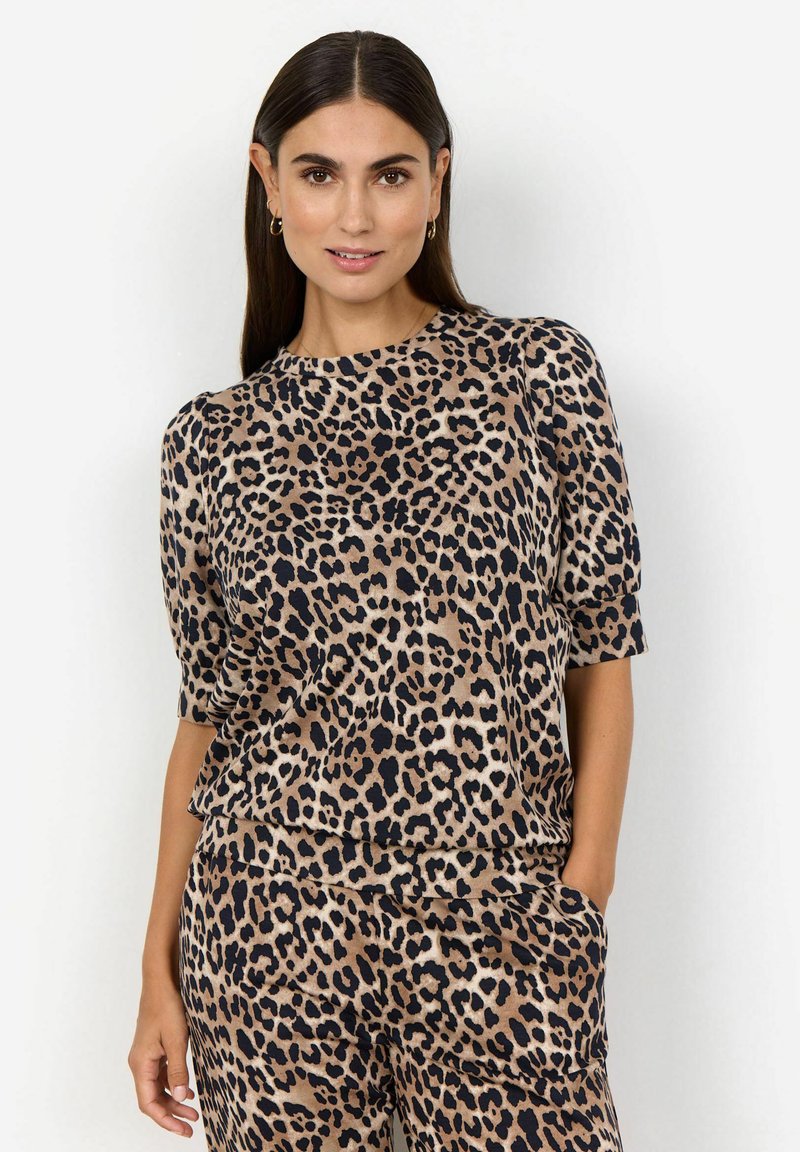 Top à imprimé léopard en tan et noir, avec des manches courtes et un col rond. Texture douce et coupe décontractée, associé à un pantalon assorti.