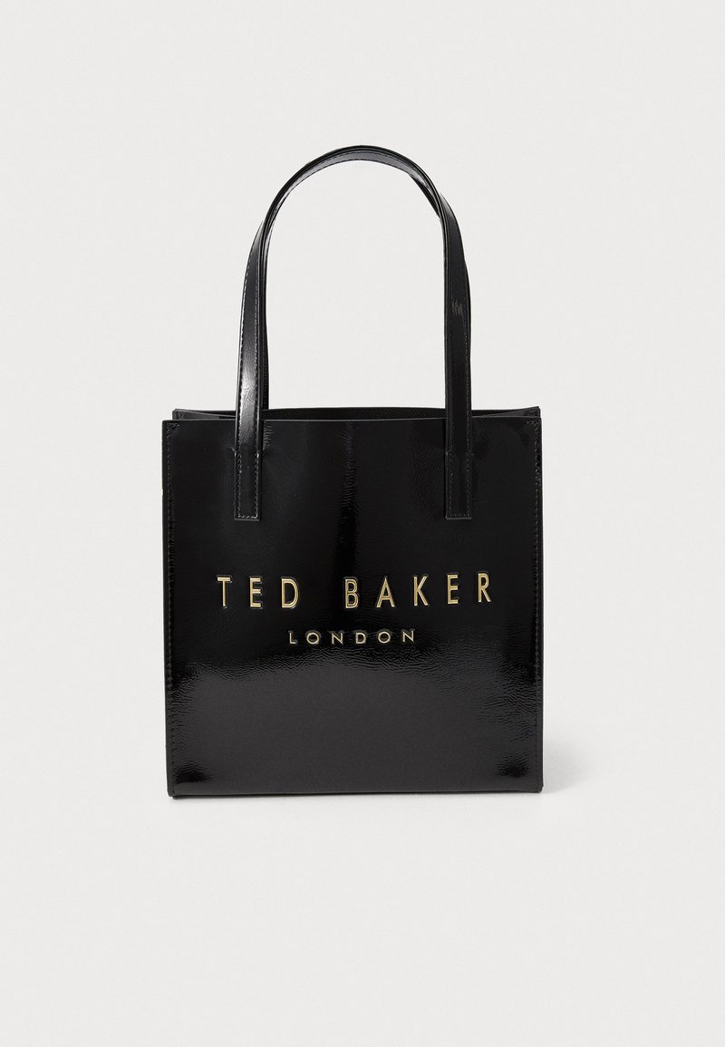 Zwarte, glanzende vegan leren tas met twee handvatten. Kenmerkt zich door "TED BAKER LONDON" in gouden letters aan de voorkant. Vierkante, minimalistische uitstraling.