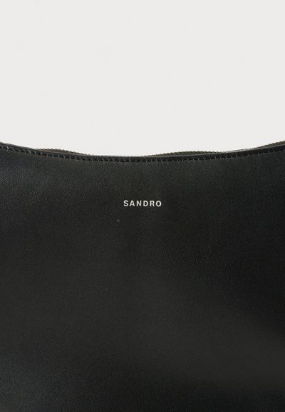 Schwarze Lederhandtasche mit einer glatten Textur, die im oberen Bereich dezent mit einem weißen "SANDRO"-Logo versehen ist, betont durch eine subtile Naht.