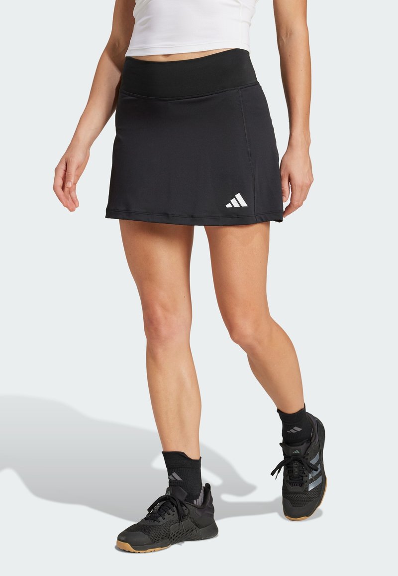 Black tennis skirt with a wide waistband, made of smooth fabric, featuring a small white Adidas logo on the lower left side.