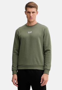 Felpa verde oliva con scollo a girocollo, polsini e orlo a coste, con logo bianco EA7 sul petto, realizzata in morbido tessuto misto cotone.