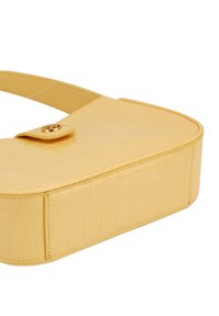 Borsa in ecopelle gialla con texture liscia, forma ovale, tracolla unica e chiusura con bottone dorato. Motivo in rilievo che richiama la pelle di coccodrillo sulla superficie.